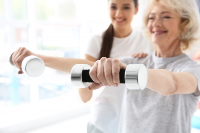 caregiver and elder woman doing physical therapy